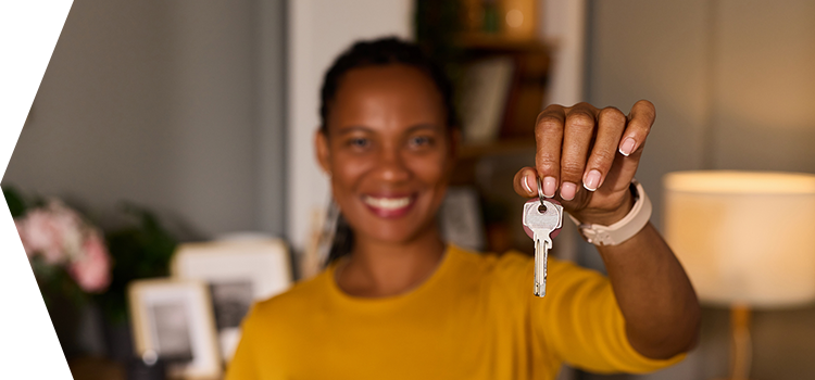 Woman holding a set of keys to her new home.