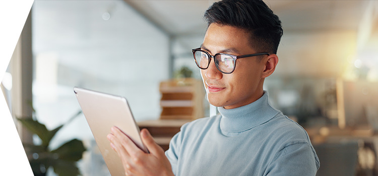 Man with glasses reading a tablet