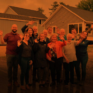 Group of people waving in front of a new housing development