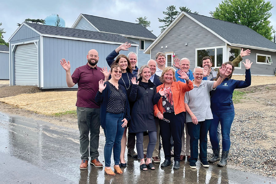 Group of people waving in front of home