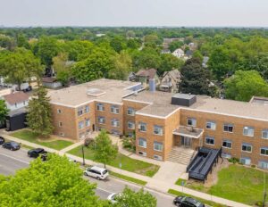 Aerial photo of two-story apartment building in tree-filled neighborhood