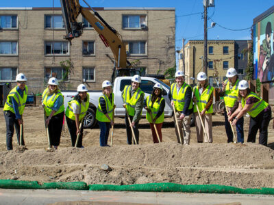 10 individuals with shovels doing the ceremonial groundbreaking at 2116 Nicollet