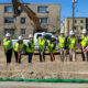 10 individuals with shovels doing the ceremonial groundbreaking at 2116 Nicollet